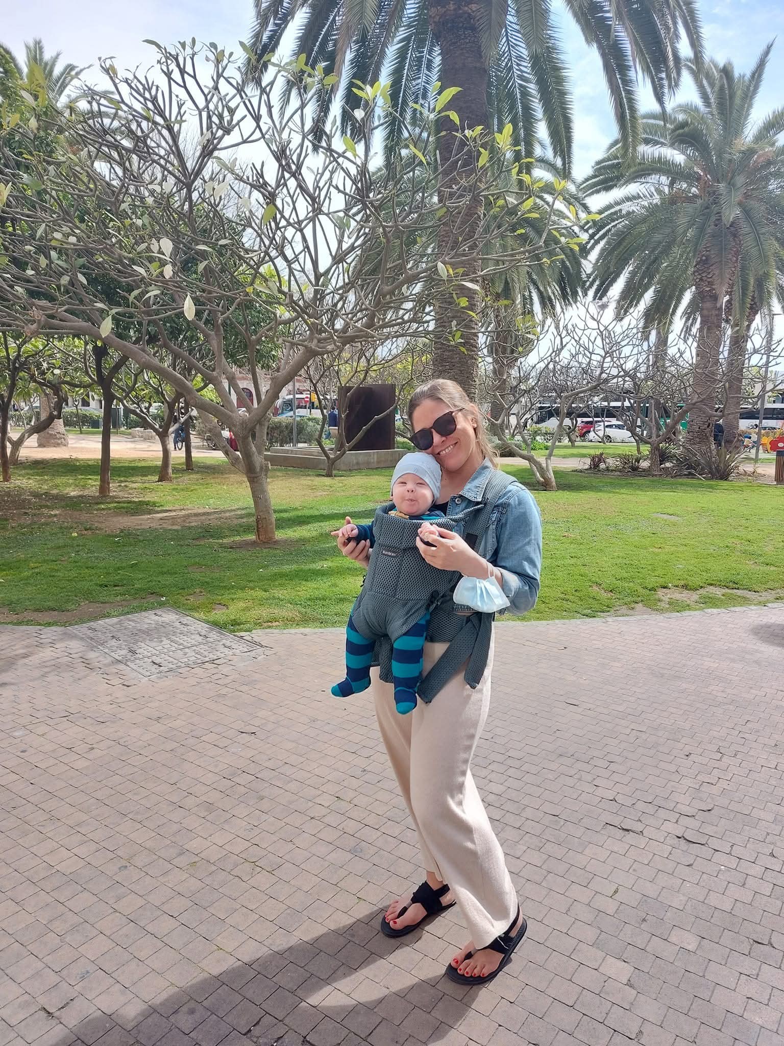 Woman holding baby in baby bjorn in Malaga, Spain.