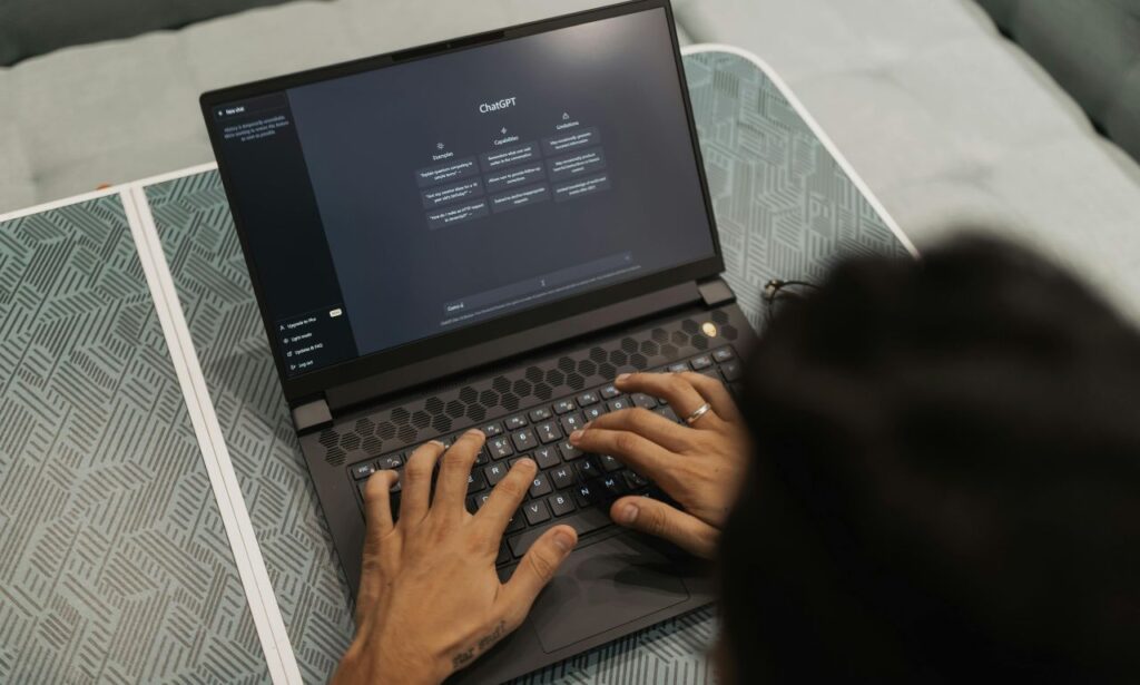 faceless woman typing into chatgpt on a laptop